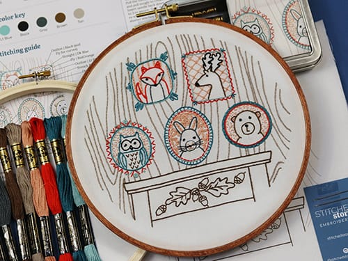 folk-inspired embroidery kit with tin, fabric pattern, hoop embroidery floss and stitching guide