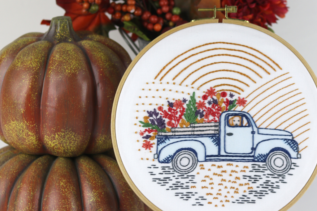 autumn-inspired embroidery pattern with vintage truck and flowers in fall colors.