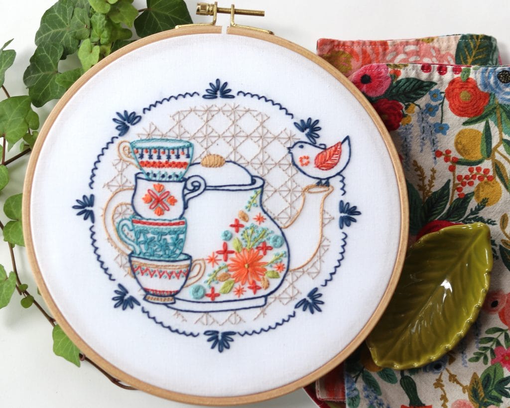 tea party embroidery pattern with tea pot and stacked teacups.
