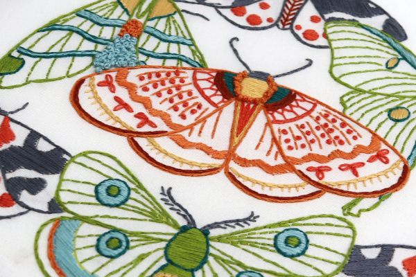 closeup of embroidery project with french knots as spots on moth 
