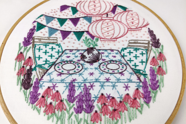 summer-themed embroidery project with garden party scene