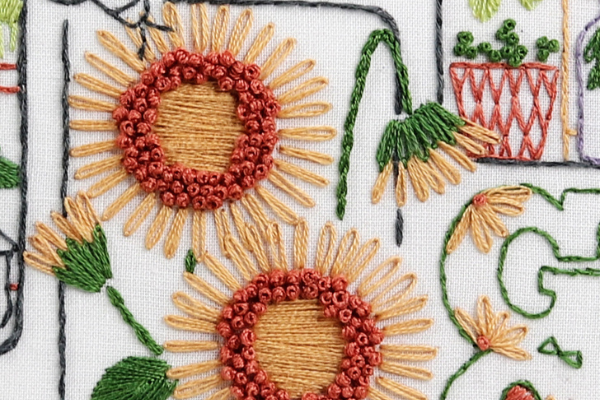 closeup of embroidery design with french knots in center of sunflower 