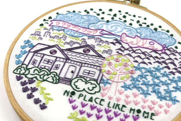 embroidery project with home in surrounding landscape
