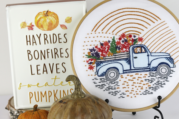 harvest-themed embroidered hoop art with vintage truck full of flowers alongside word art and decorative pumpkins