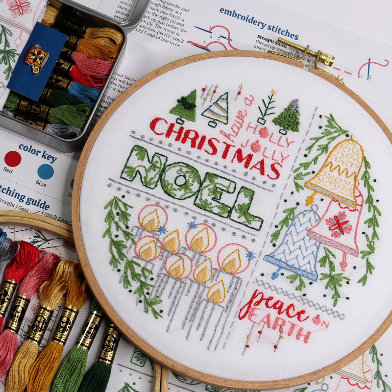 Christmas-themed embroidery hoop art with holiday messages, bells, candles and pine trees 