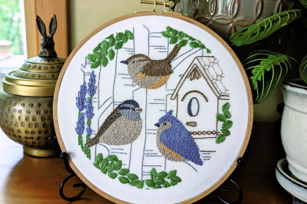 Displayed hoop art with small birds and plants