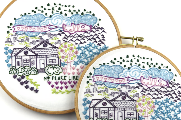 Embroidered hoop art of city, mountains and house