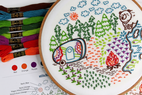 Embroidered hoop art of camping, campfire and forest