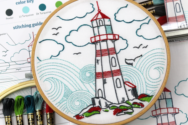 Embroidered hoop art of lighthouse, waves and clouds