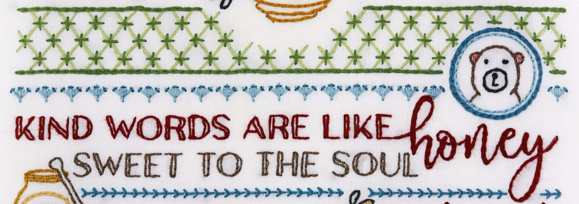 Embroidered detail from traditional embroidery stitch sampler with honeybee themes