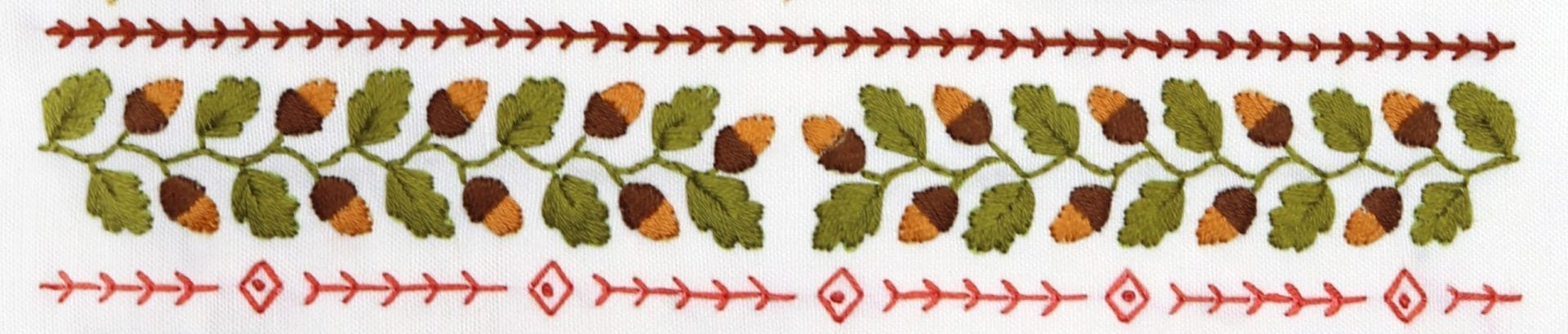 Embroidered detail from traditional embroidery stitch sampler with fall themes