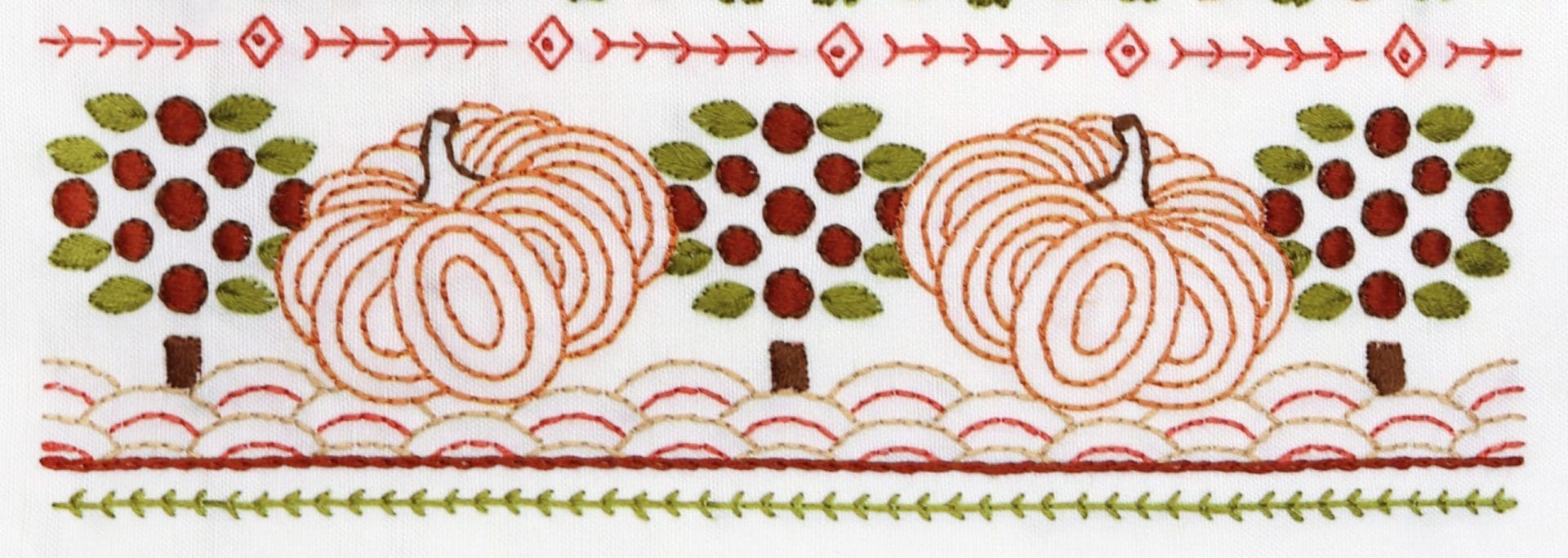 Embroidered detail from traditional embroidery stitch sampler with fall themes