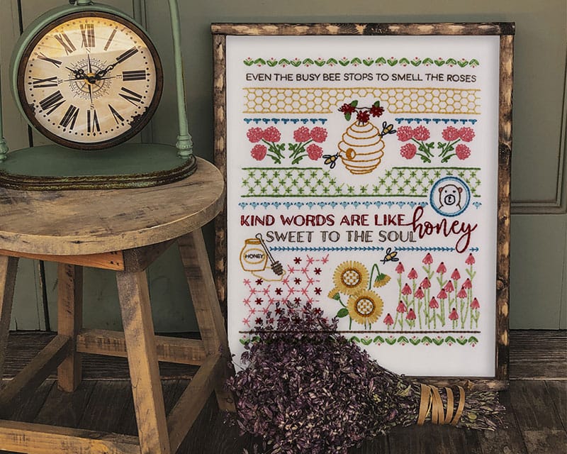 framed honeybee embroidery sampler with rustic styling