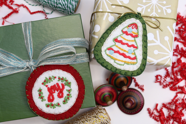 embroidered ornaments used as tags on wrapped Christmas gifts.